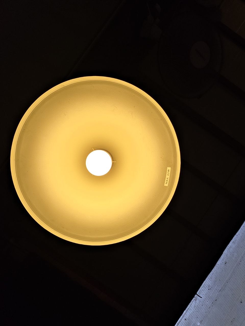 Warm gold pendant lamp shot from below, almost abstract